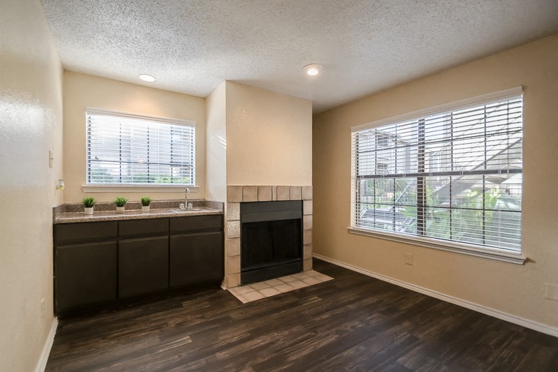 an empty kitchen with a fireplace and a window