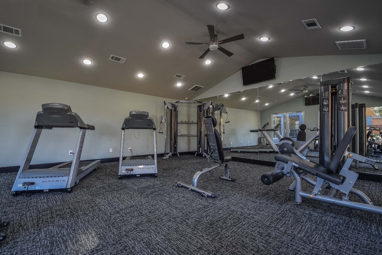 spacious gym with cardio machines and weights in the clubhouse of aria on the avenue