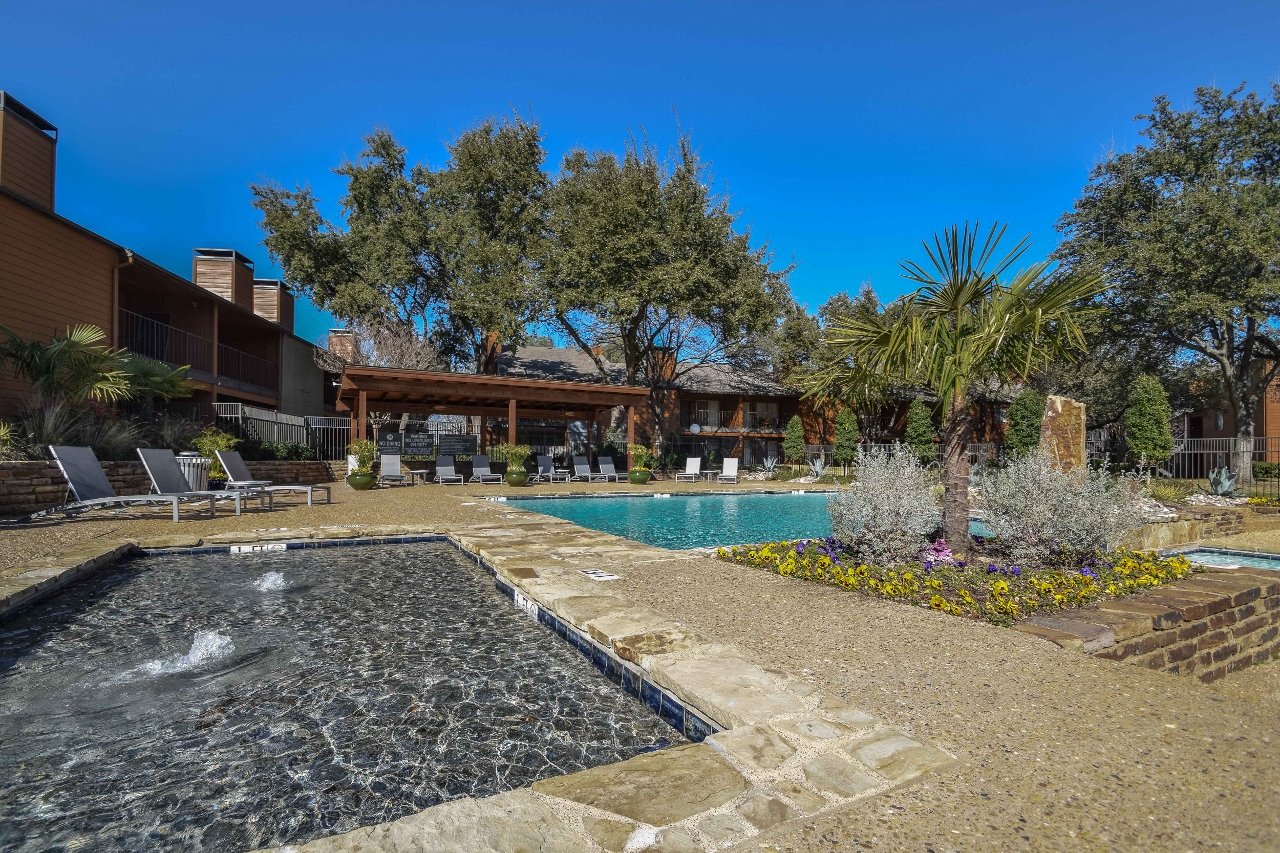 a backyard with a pool and trees and a house