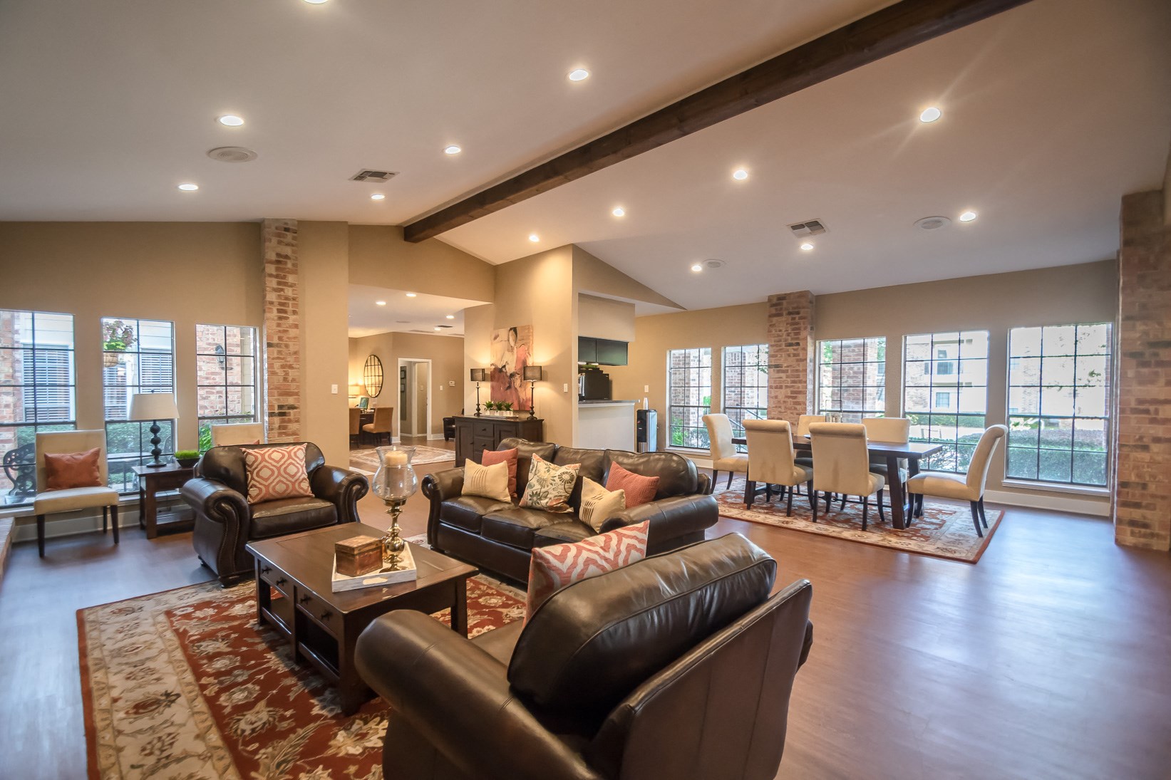 a large living room with leather furniture and a dining room with a table and chairs