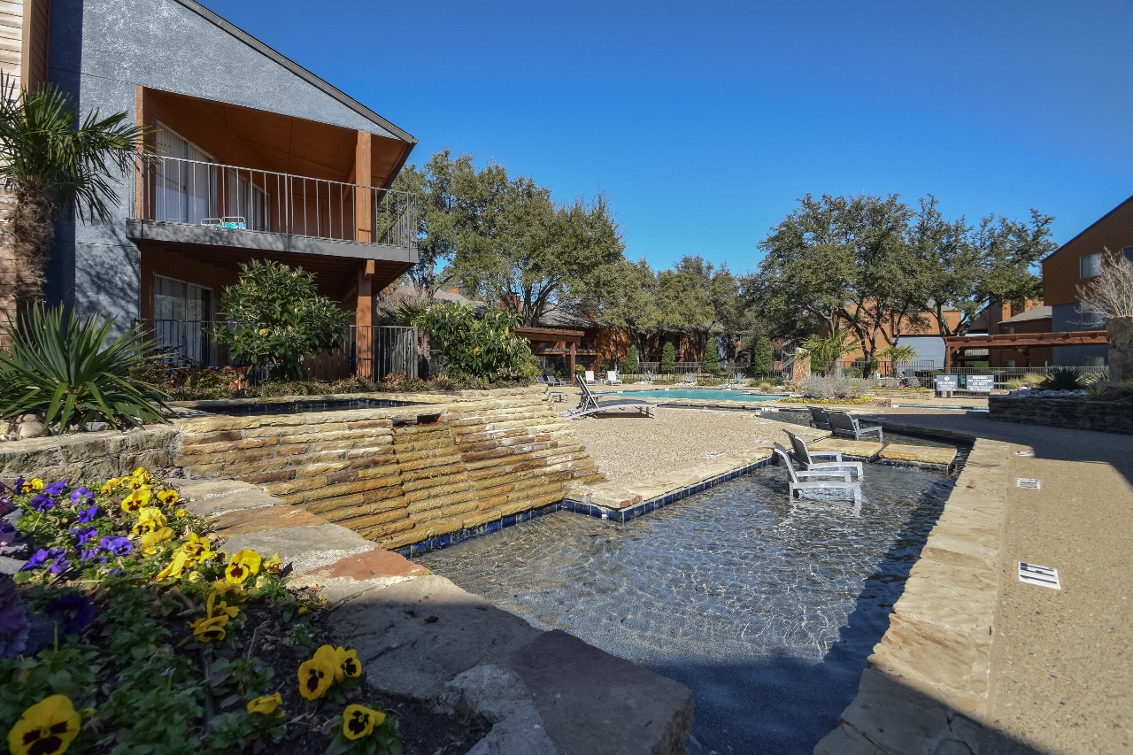 a backyard with a swimming pool and a patio with a chair in the water