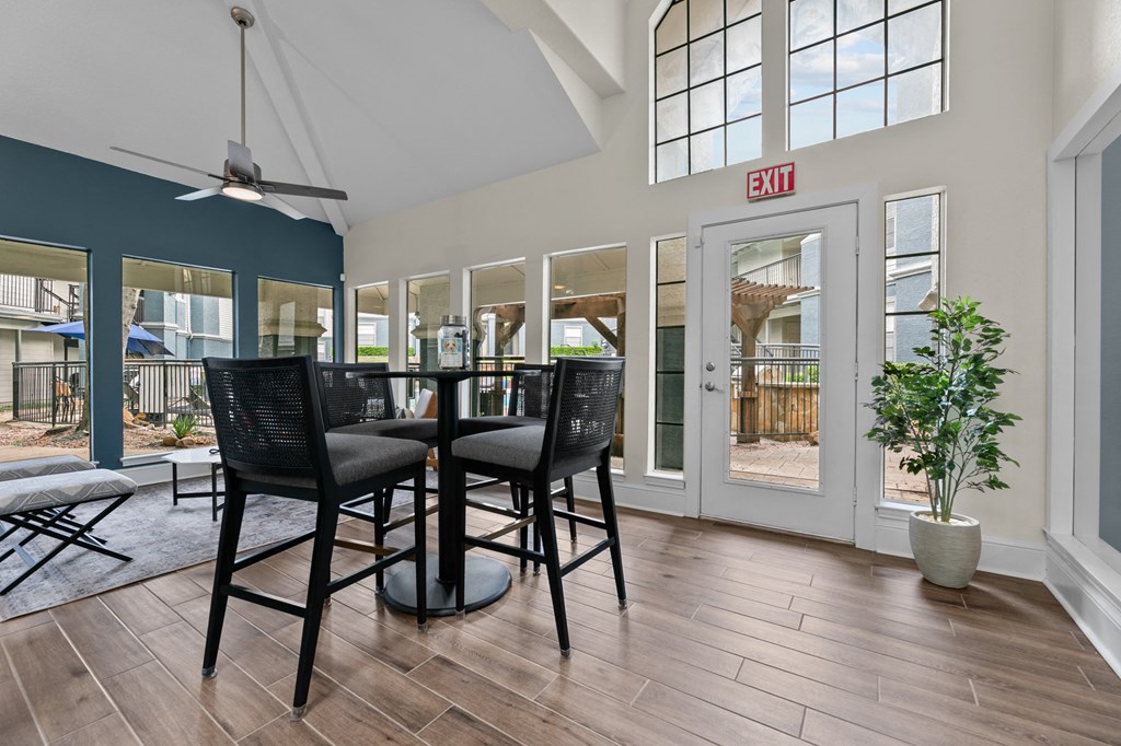 a dining room with a table and chairs and a exit sign