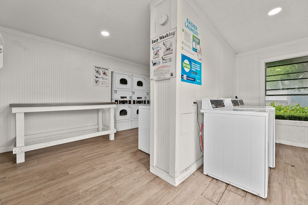 a laundry room with white appliances and a counter