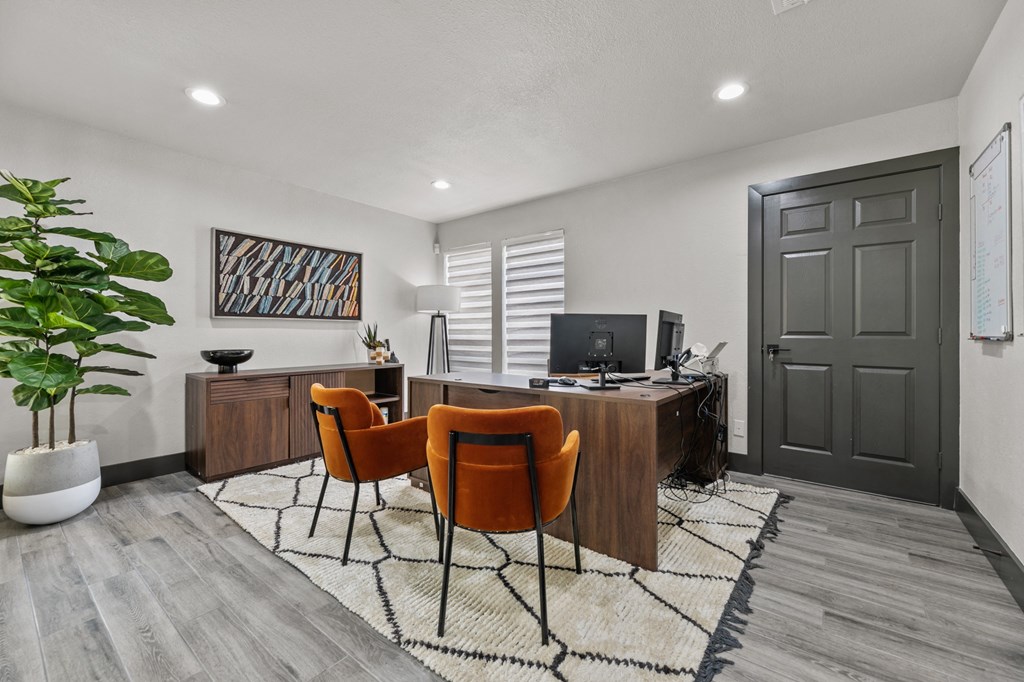 a home office with a wooden desk and orange chairs at The Hills at Ironhorse, North Richland Hills, Texas