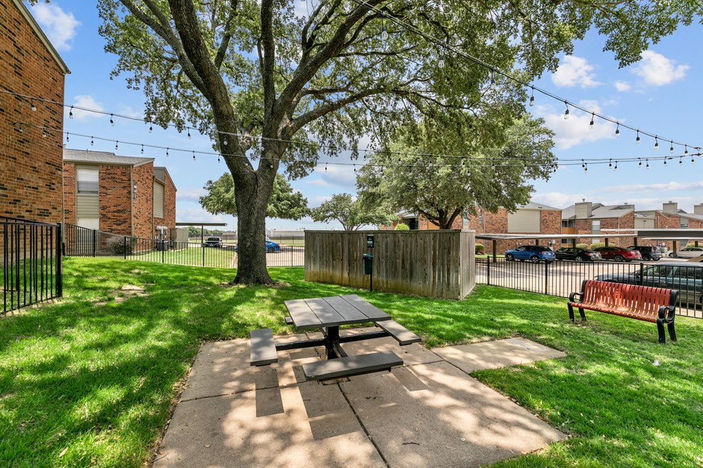 a picnic area with a table and benches in the middle of a grassy area at The Hills at Ironhorse, North Richland Hills, TX, 76180