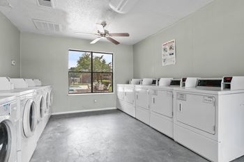 A laundromat with a row of washers and dryers.