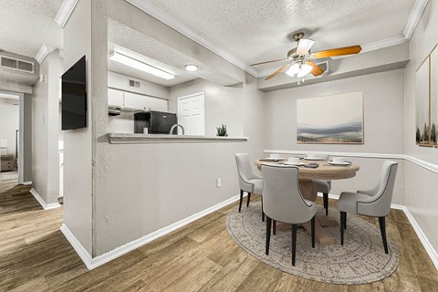 a dining room with a table and chairs and a ceiling fan at 5636 Apartment Homes, Dallas, TX
