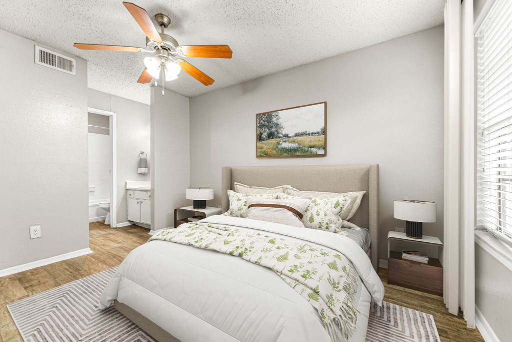 a bedroom with a large bed and a ceiling fan