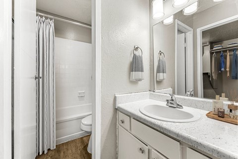 a bathroom with a sink and a shower and a mirror at 5636 Apartment Homes, Dallas, TX