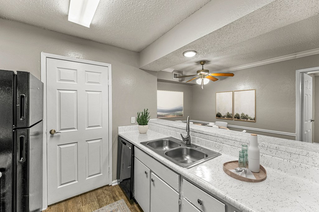 a kitchen with a sink and a ceiling fan