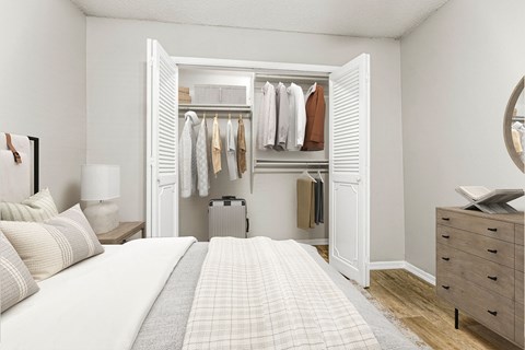 a bedroom with a bed and a closet full of clothes at 5636 Apartment Homes, Dallas, TX