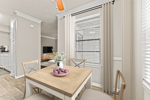 a dining room with a table and chairs and a large window at 5636 Apartment Homes, Dallas