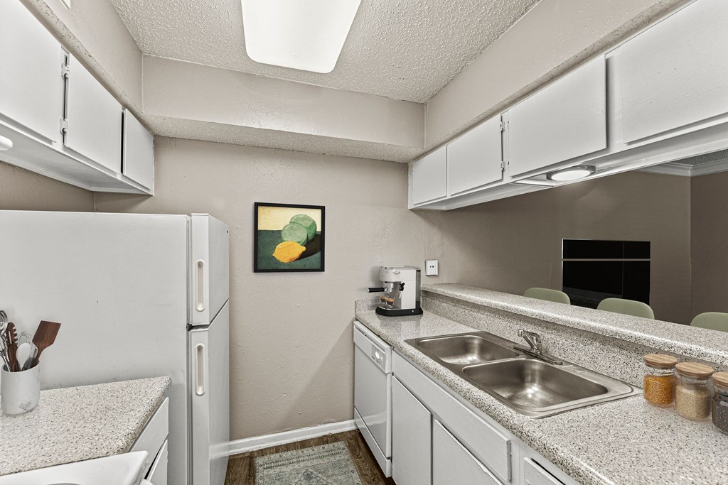 a kitchen with white cabinets and a sink and a refrigerator