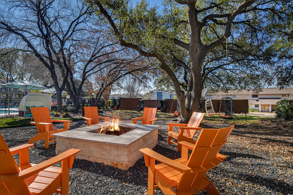 a group of orange chairs around a fire pit at Peaks at Northwest Hills Apartments, Texas, 78731
