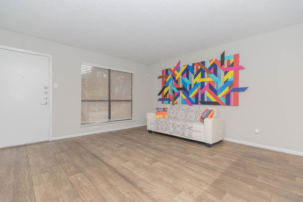 a living room with a couch and a painting on the wall