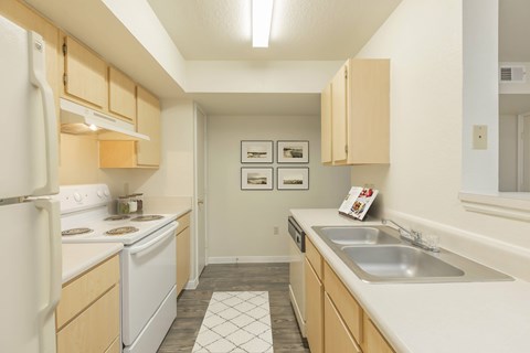 A kitchen with white appliances and wooden cabinets.
