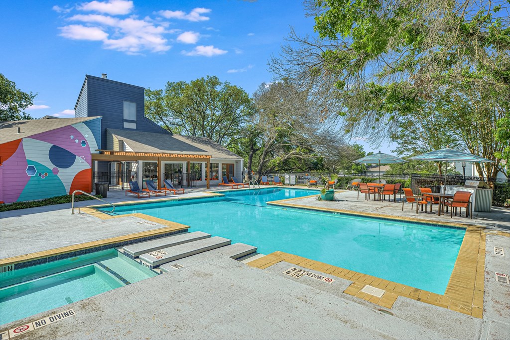 a swimming pool with a house in the background at Peaks at Northwest Hills Apartments, Austin, TX