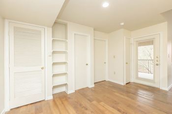 A room with white walls and wooden floors.