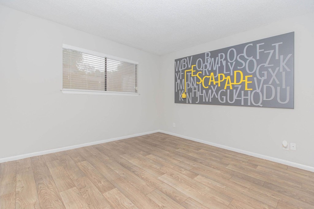 an empty room with wood floors and a window