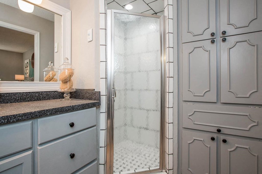 a bathroom with white cabinets and a reflection of lights on the wall