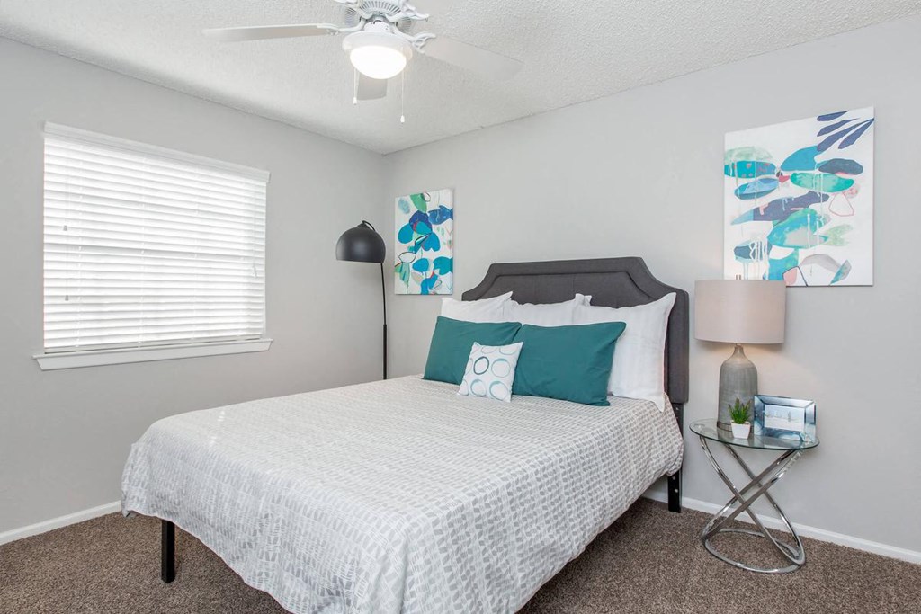 a bedroom with a bed and a ceiling fan