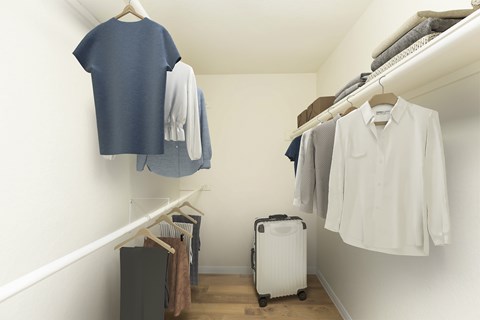 A white shirt is hanging on a rack in a room.
