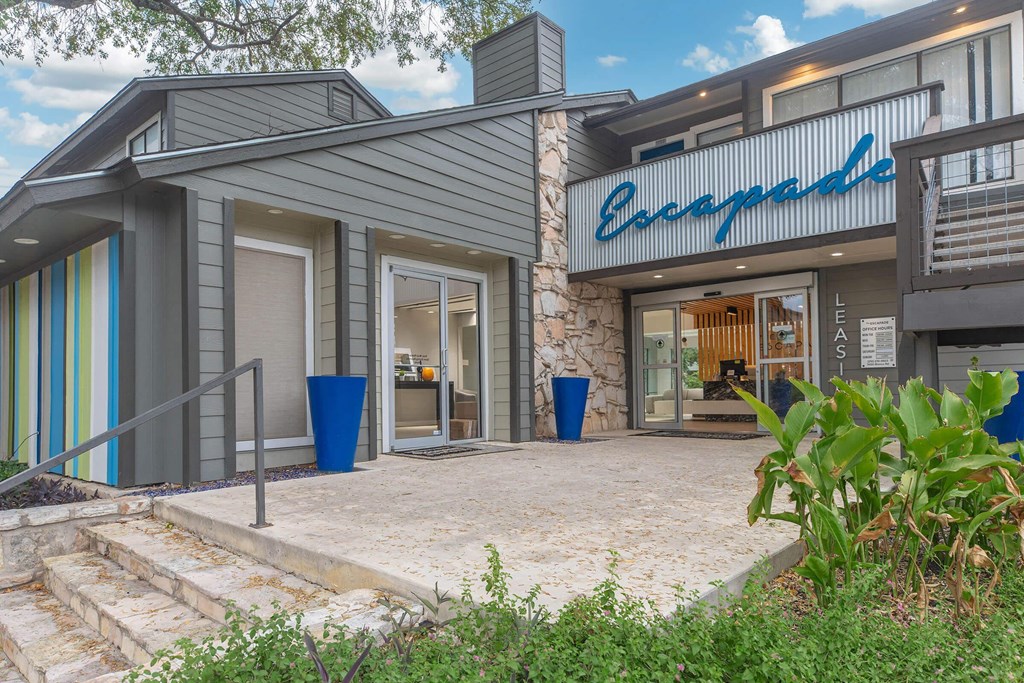 a view of the front of a building with stairs and a sidewalk