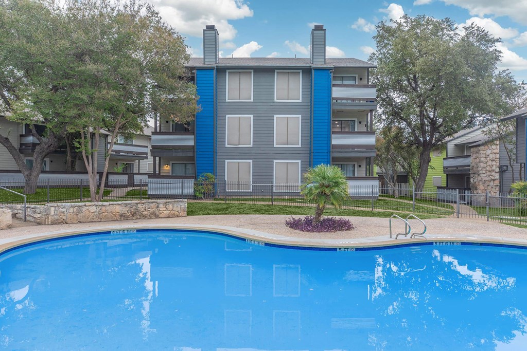 a large swimming pool with an apartment building in the background