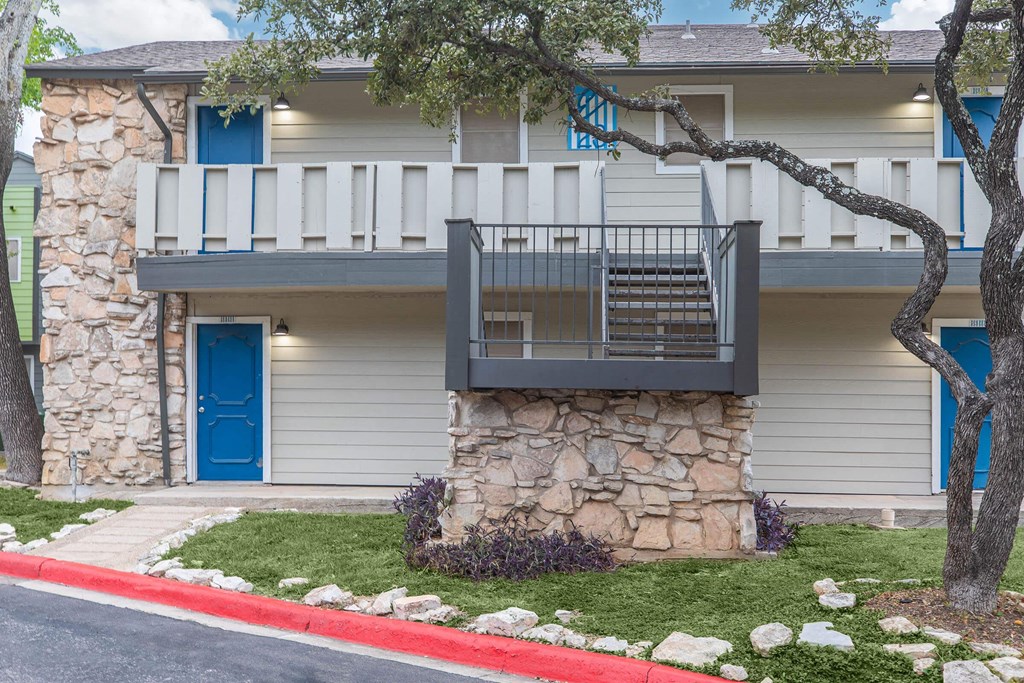 a stone building with a balcony and a blue door