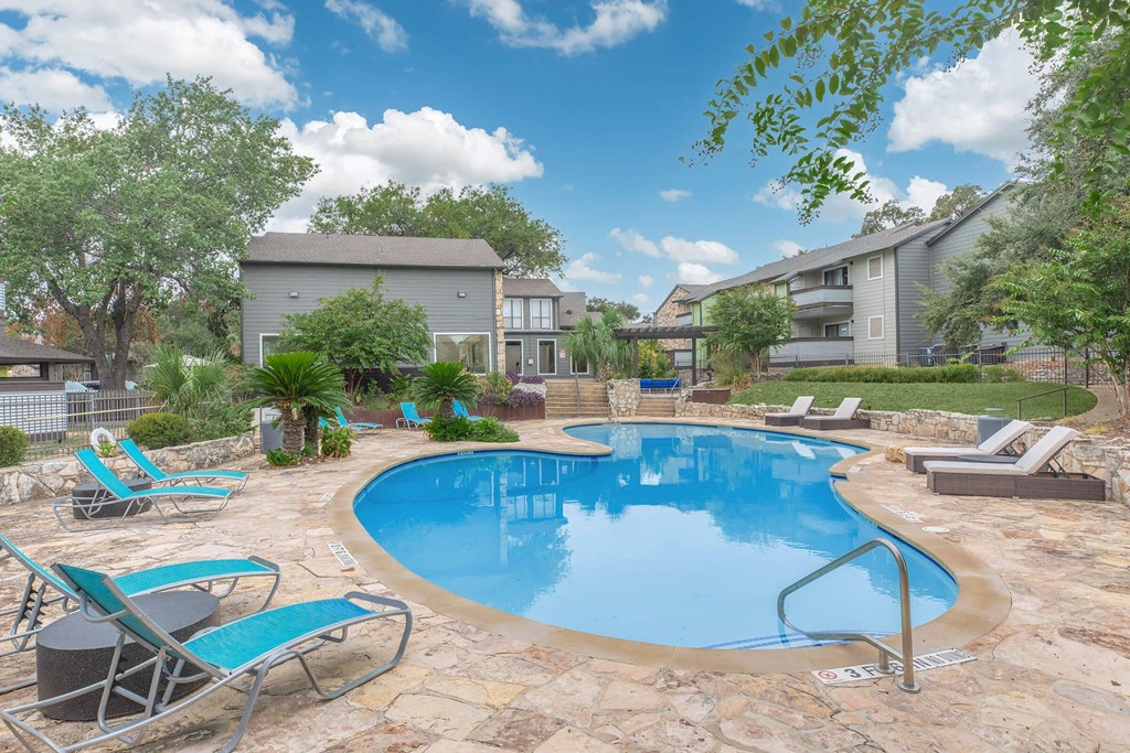 a swimming pool with chairs and a house in the background stock photography