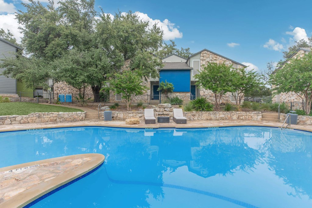 a swimming pool with a house in the background