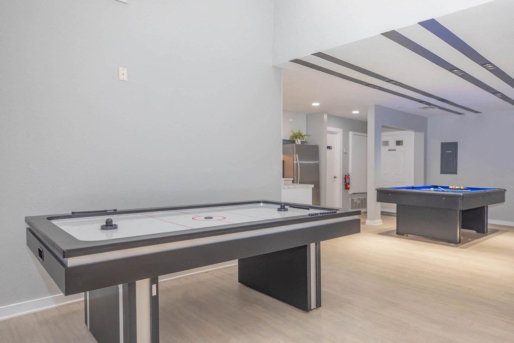 a game room with two pool tables and a foosball