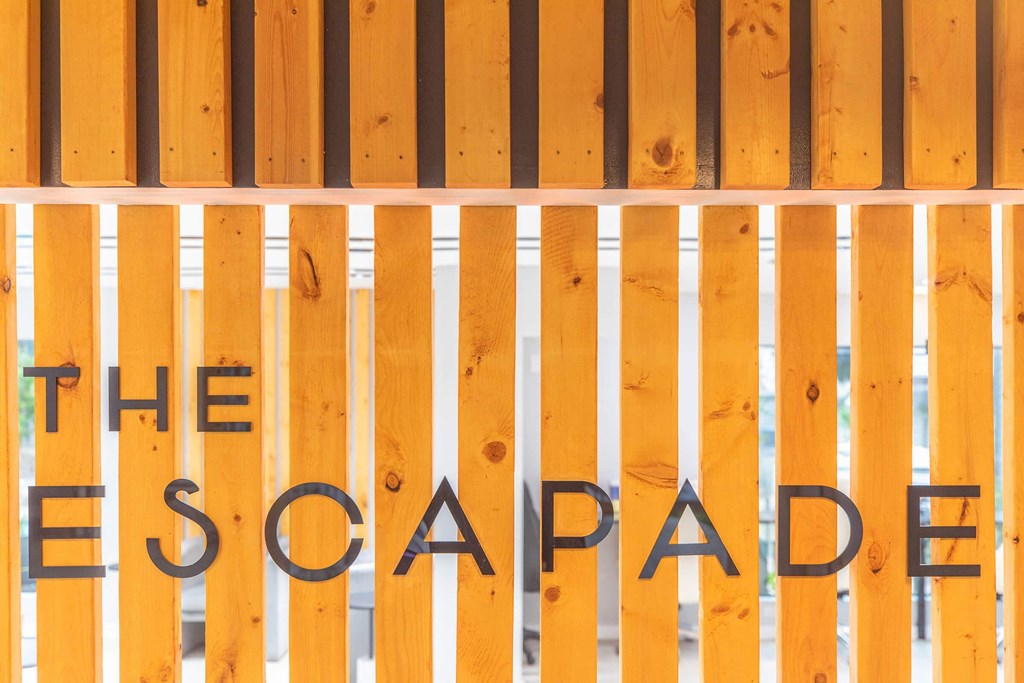 a sign for the escape room is painted on a wooden gate