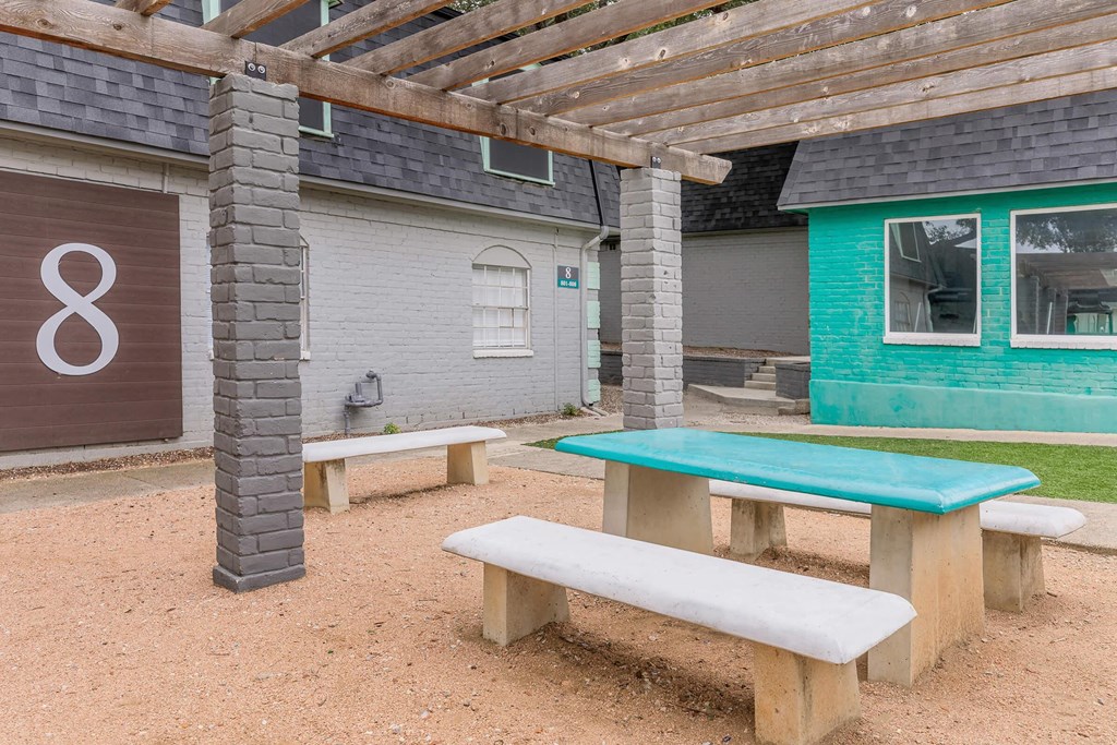 a picnic area with benches and a table in front of a building