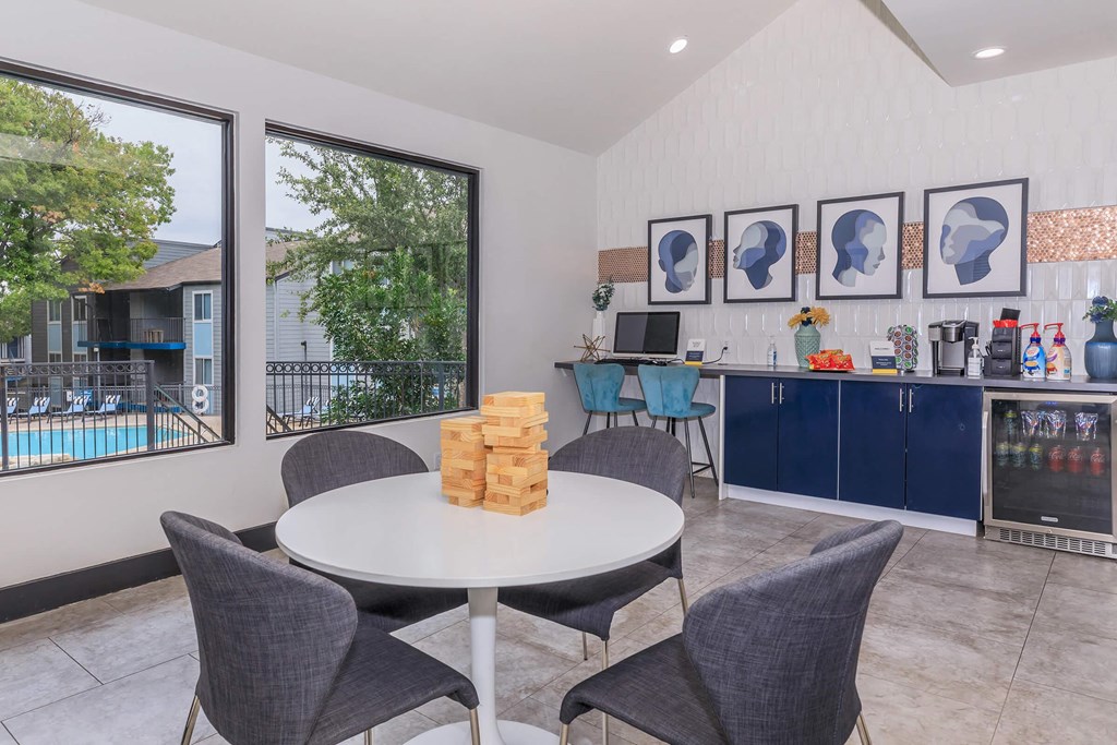 a dining area with a table and chairs and a kitchen with a pool