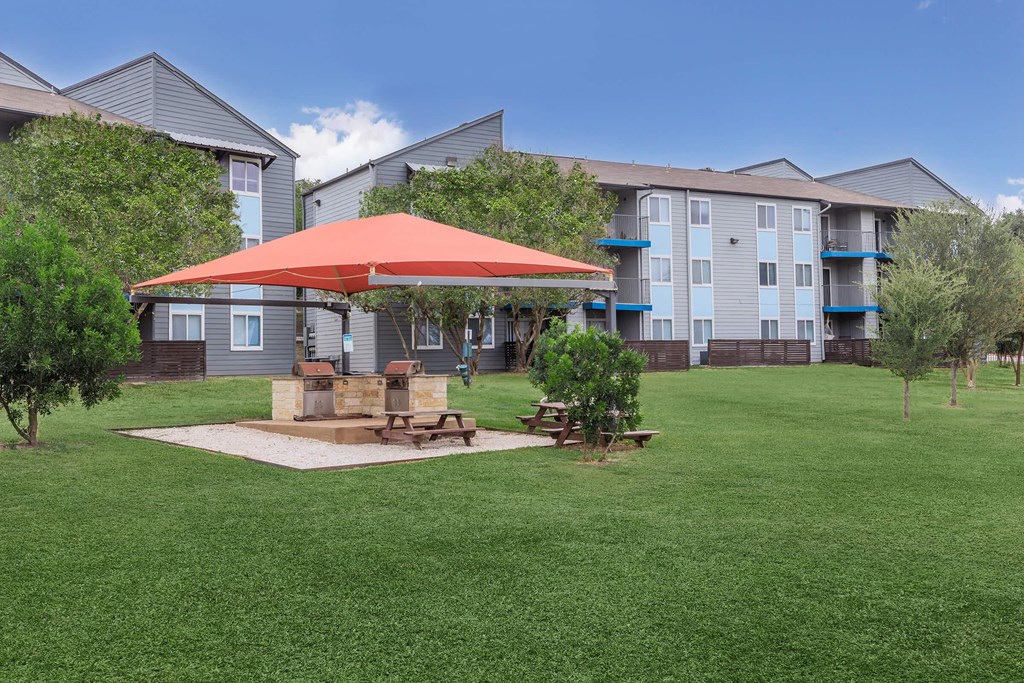 our apartments have a large yard with a picnic table and umbrella