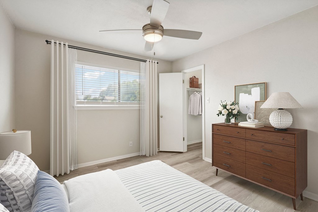 a bedroom with a ceiling fan and a dresser