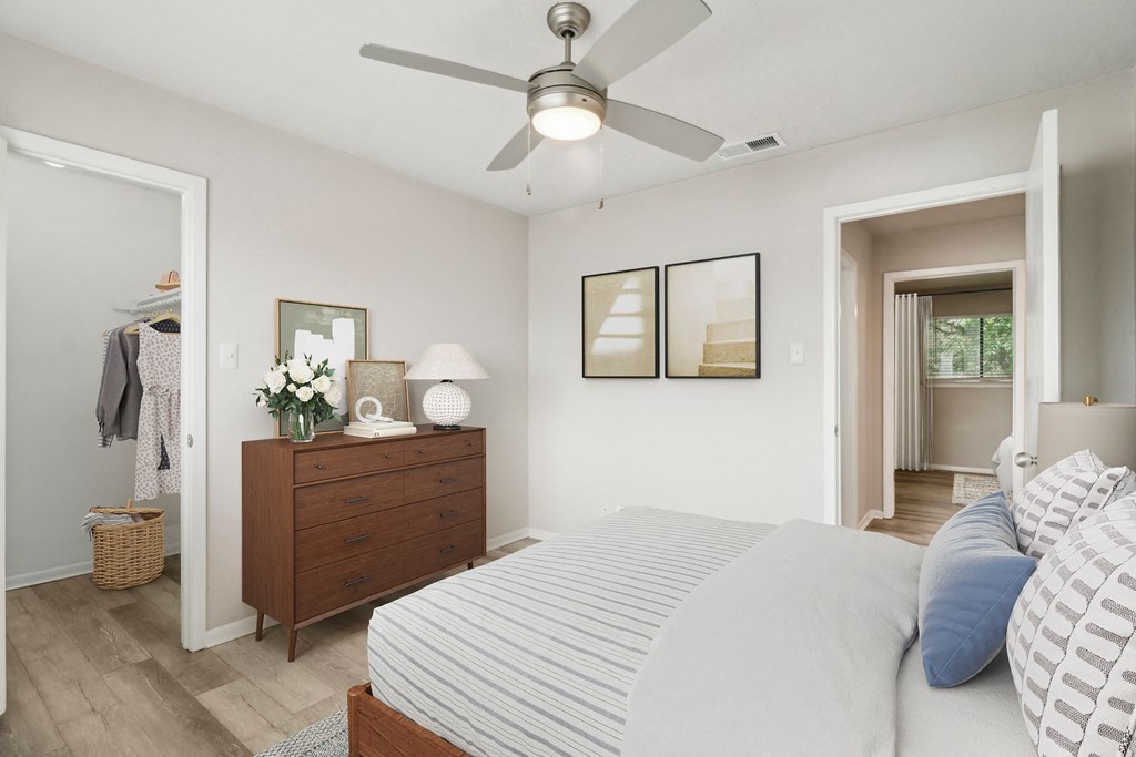 a bedroom with a large bed and a ceiling fan