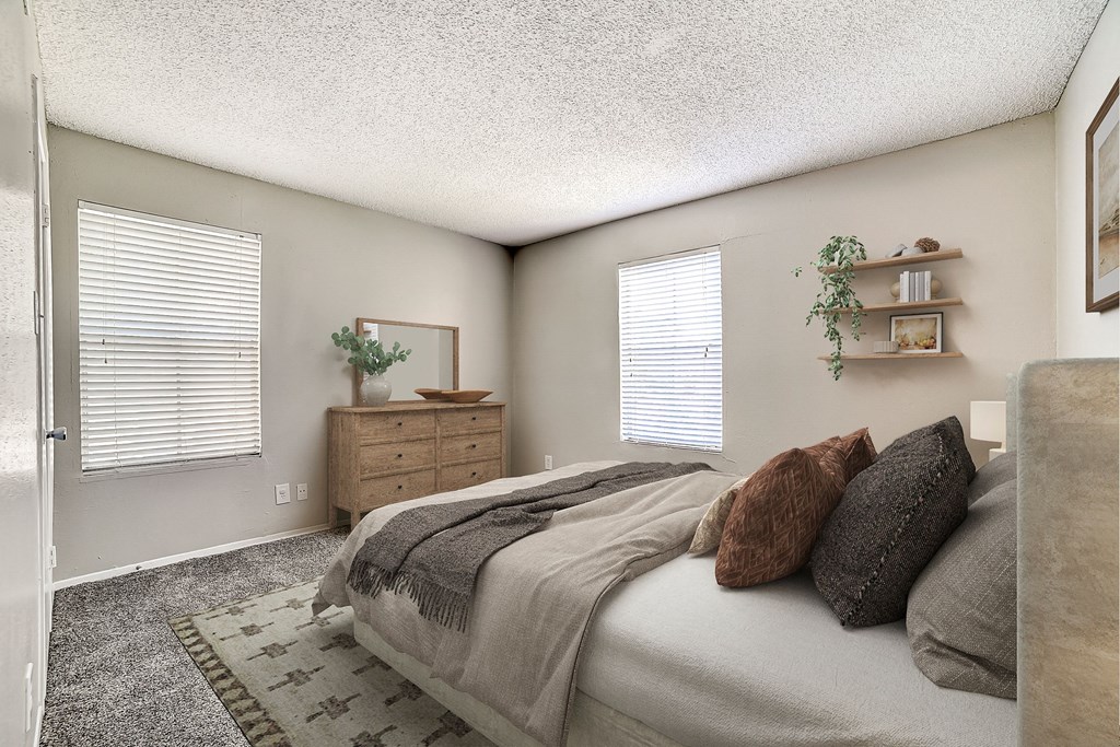 a bedroom with a bed and two windows