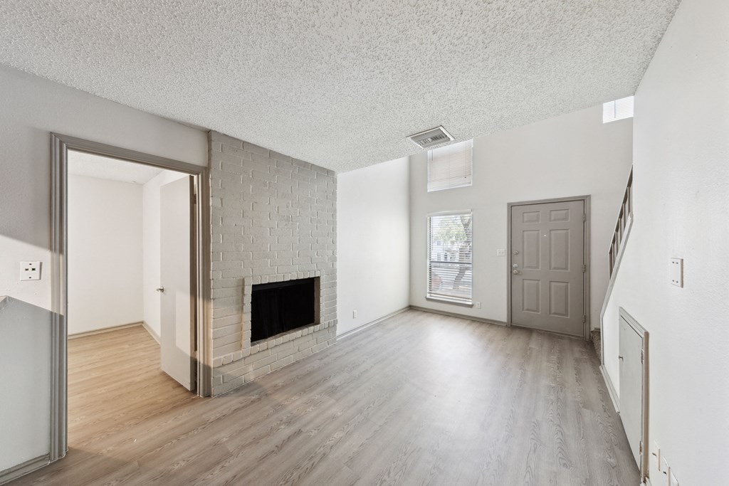 the living room and dining room of an apartment with a fireplace at Maxwell Townhomes, San Antonio, TX, 78230