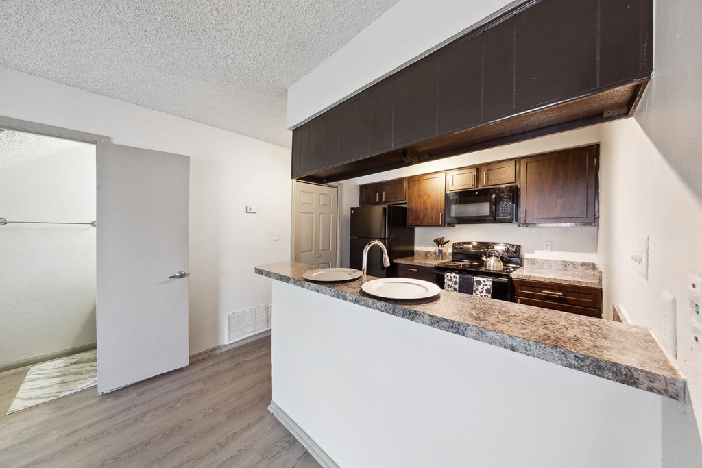 a kitchen with a counter top and a refrigerator at Maxwell Townhomes, San Antonio, Texas