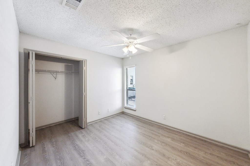 an empty room with a closet and a ceiling fan at Maxwell Townhomes, Texas