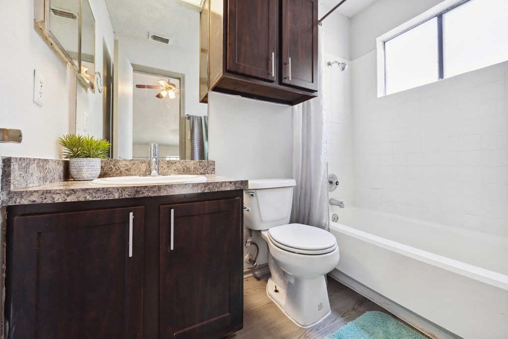 a bathroom with a toilet and a sink and a bath tub at Maxwell Townhomes, San Antonio, TX