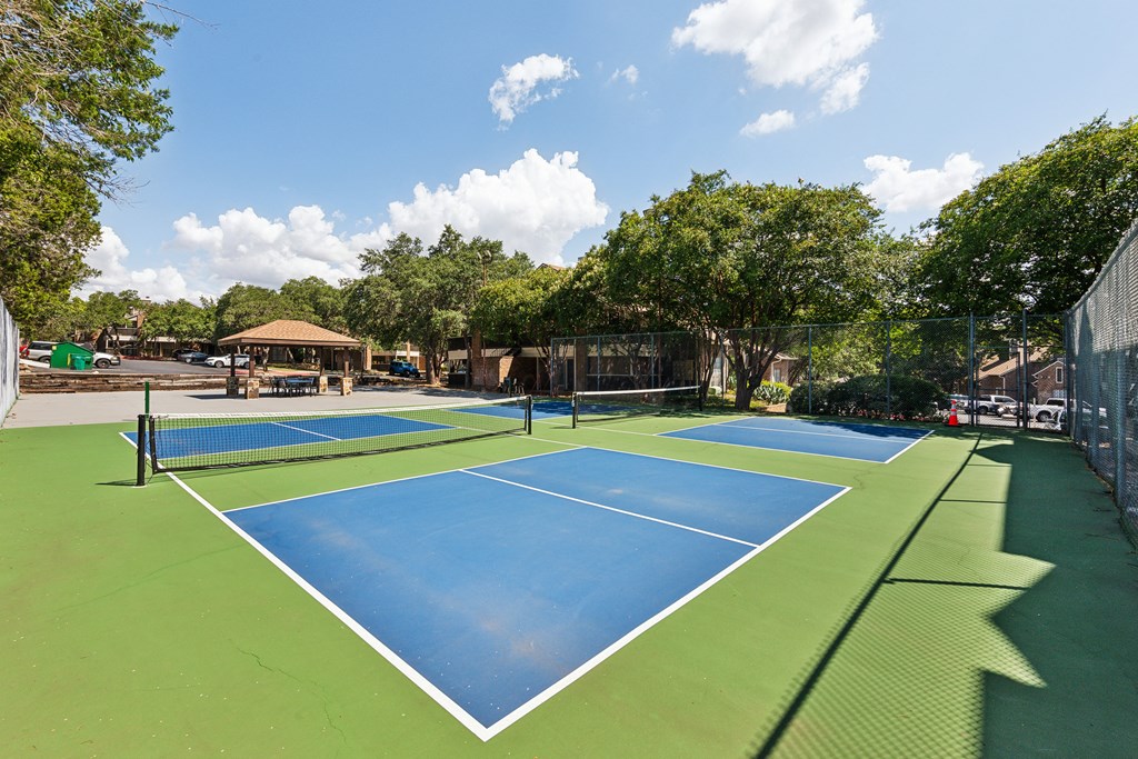 a pickleball court with two blue and green tennis courts