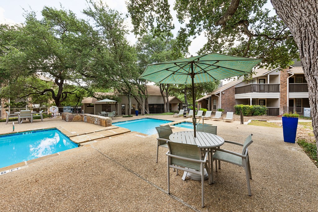 our apartments have a pool and a patio with a table and chairs