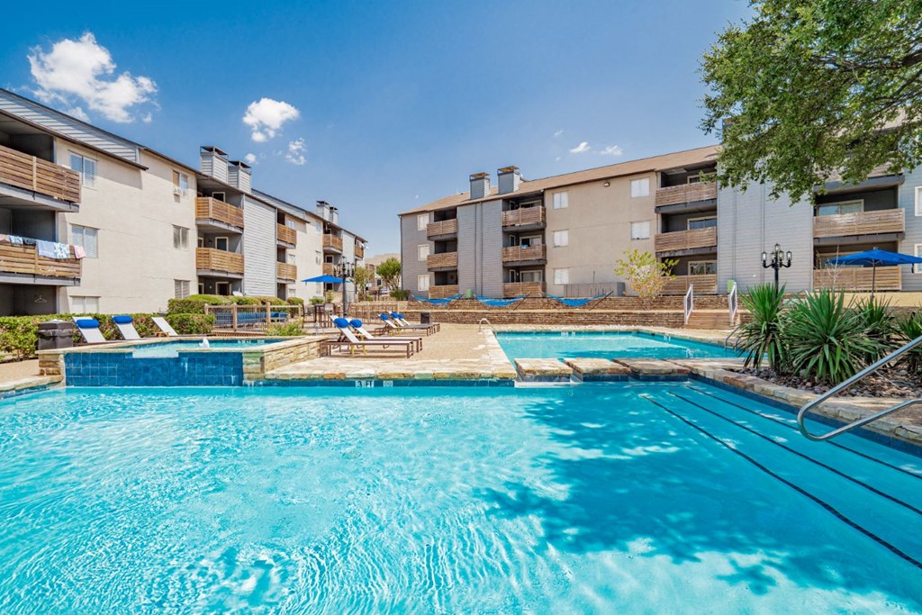 our apartments have a large swimming pool with an apartment building in the background