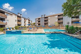 our apartments have a large swimming pool with an apartment building in the background