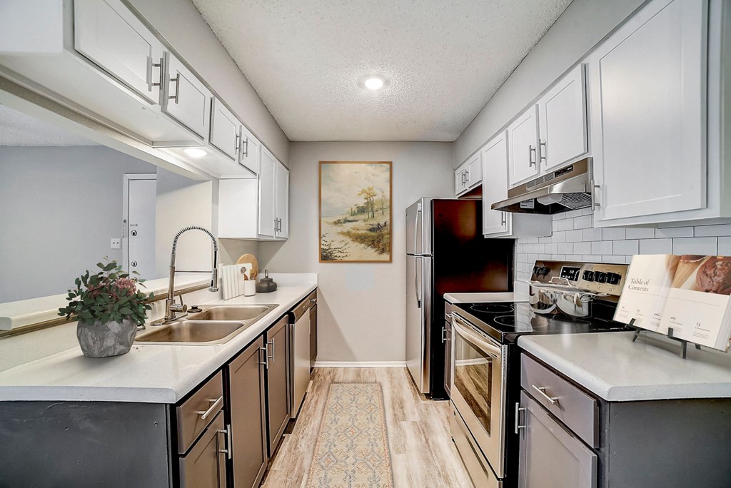 a kitchen with white cabinets and black appliances