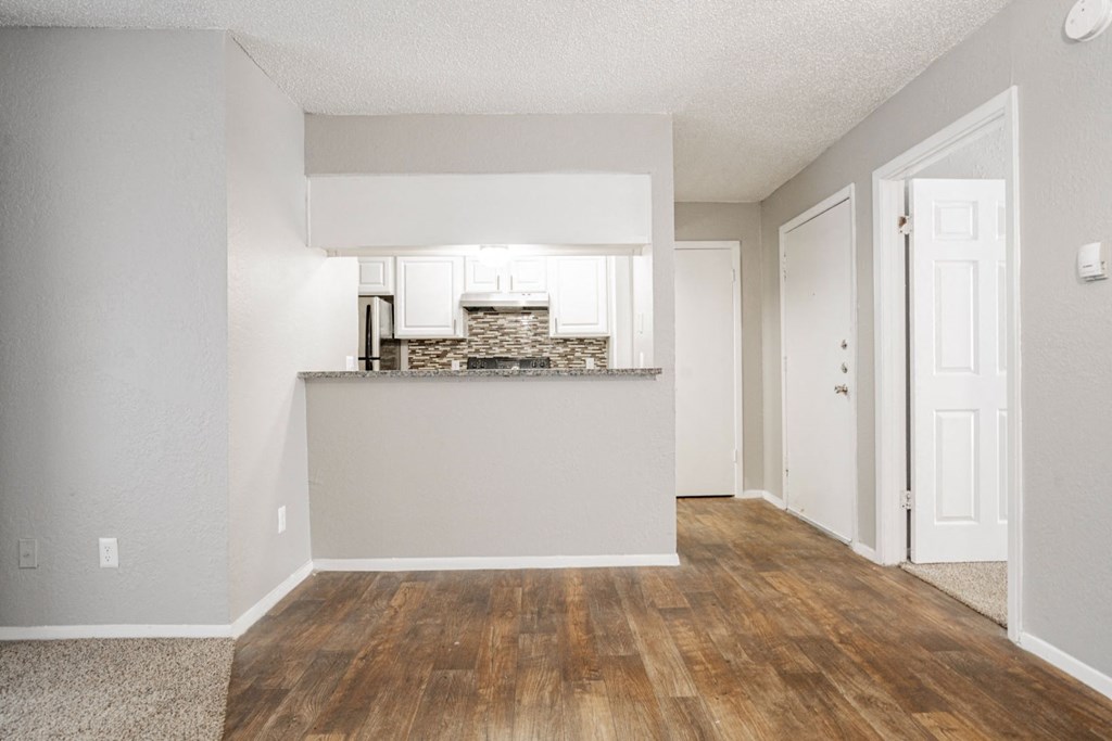 the spacious living room and kitchen of an apartment