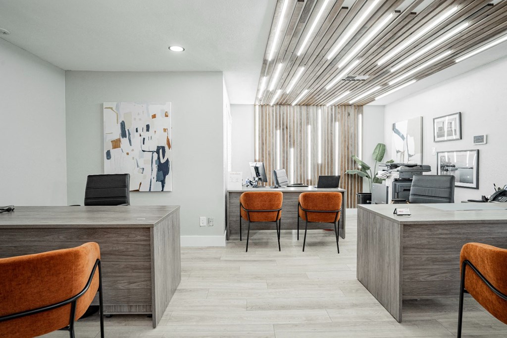 a lobby with orange chairs and a reception desk